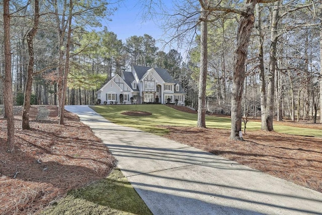 view of front of house featuring concrete driveway and a front lawn