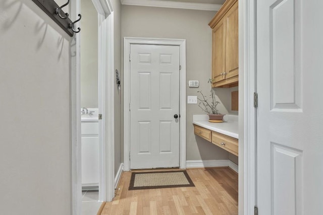 interior space with light wood-style flooring, baseboards, and built in desk