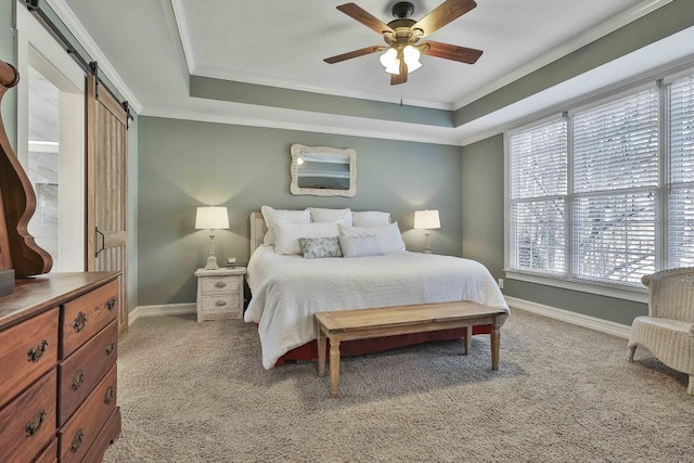 bedroom featuring a tray ceiling, a barn door, light carpet, and ornamental molding