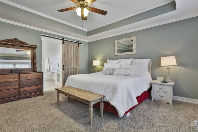 carpeted bedroom with a barn door, a tray ceiling, and ornamental molding