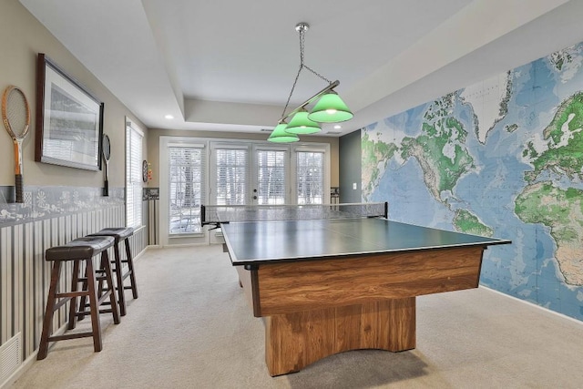 playroom with a tray ceiling, recessed lighting, wallpapered walls, light colored carpet, and an accent wall