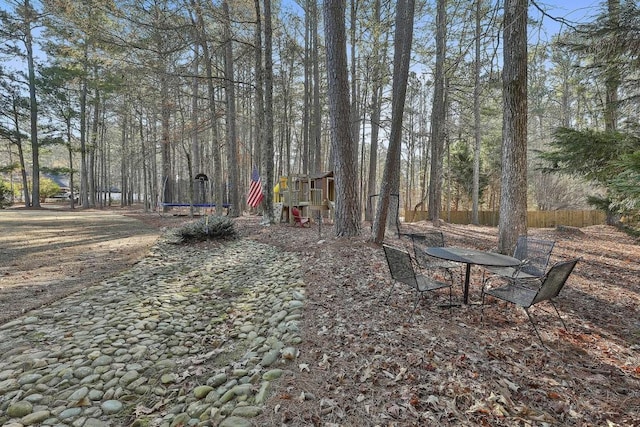 view of yard featuring a trampoline and fence