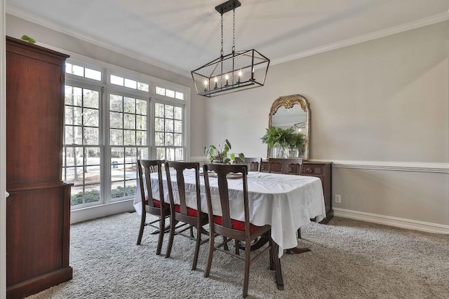 dining space featuring baseboards, carpet floors, an inviting chandelier, and crown molding