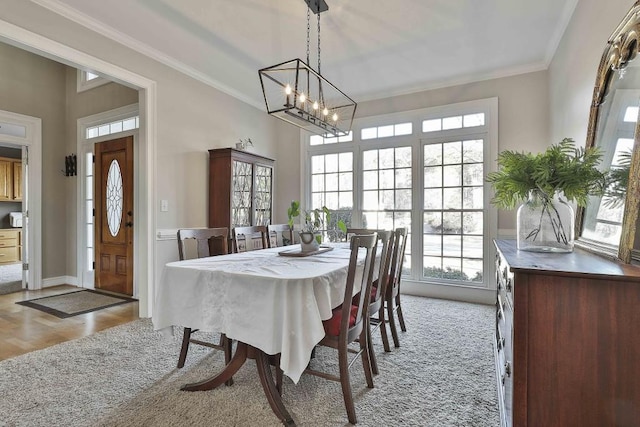 dining space with a notable chandelier, baseboards, and ornamental molding