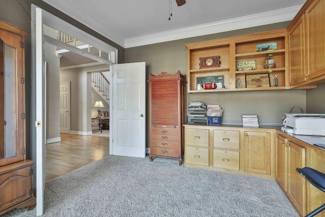 home office featuring light carpet, baseboards, ceiling fan, and ornamental molding