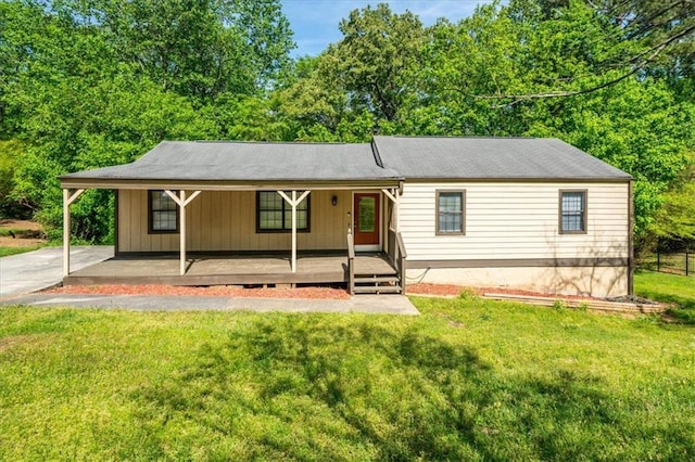 view of front of home with a front yard, covered porch, and an attached carport