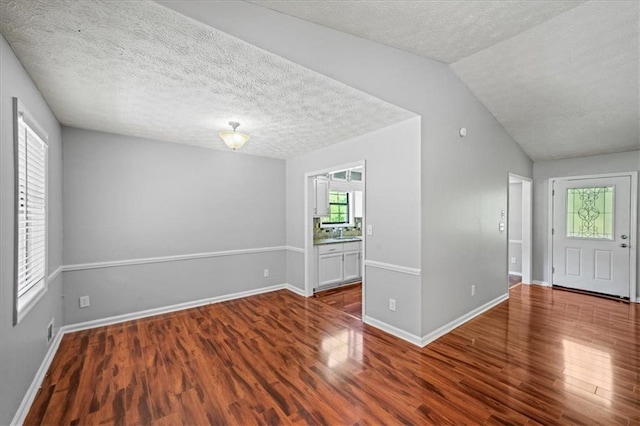 entrance foyer featuring baseboards, wood finished floors, and a textured ceiling