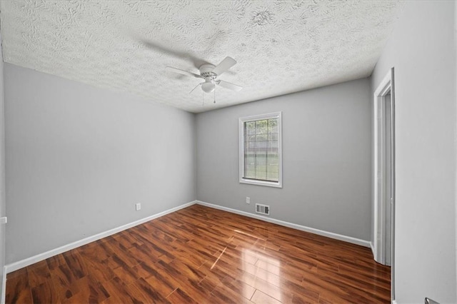 empty room with wood finished floors, visible vents, baseboards, and ceiling fan