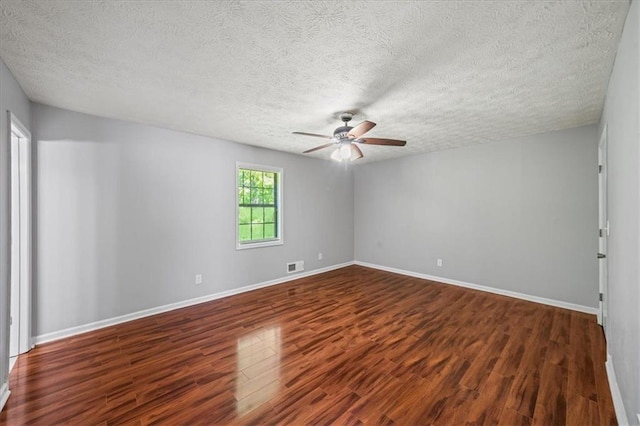empty room with ceiling fan, baseboards, wood finished floors, and visible vents