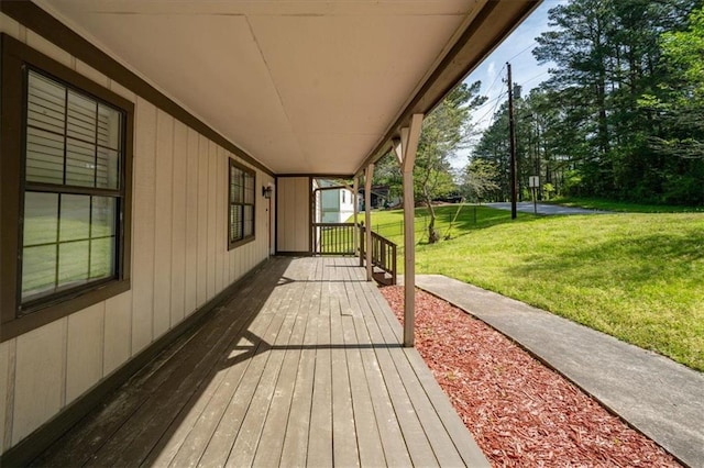 wooden terrace with a yard and covered porch