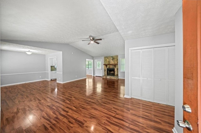 unfurnished living room with baseboards, wood finished floors, a textured ceiling, and ceiling fan