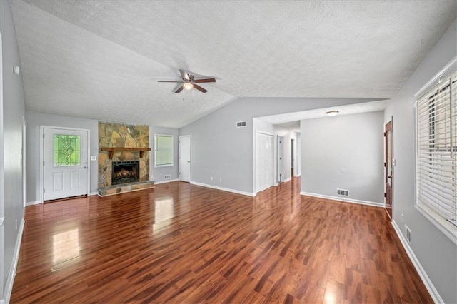 unfurnished living room with lofted ceiling, a ceiling fan, wood finished floors, and a textured ceiling
