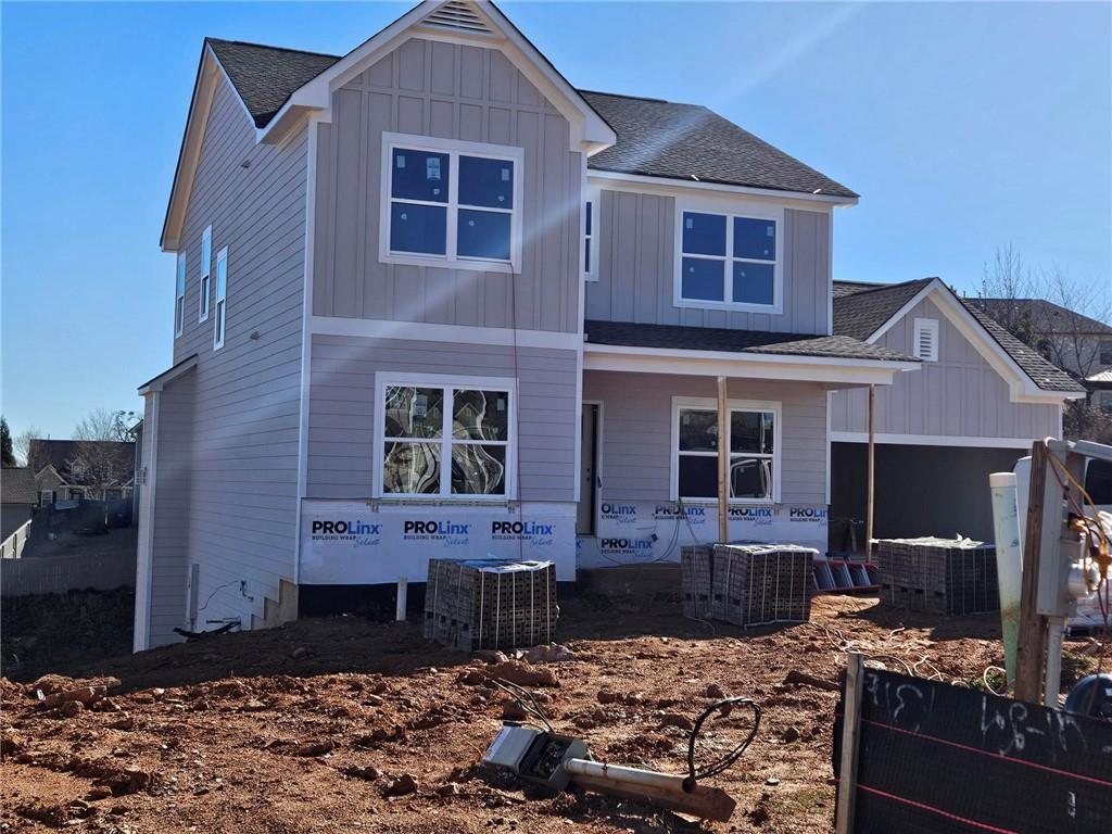 view of front of house featuring board and batten siding, covered porch, a shingled roof, and central AC unit