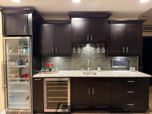 1984 Mendenhall Cir, Atlanta, GA 30341 - kitchen with beverage cooler, a sink, stainless steel microwave, decorative backsplash, and recessed lighting