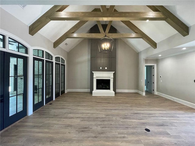 unfurnished living room featuring beamed ceiling, high vaulted ceiling, a fireplace, and light hardwood / wood-style floors