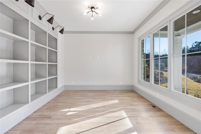 unfurnished room with ornamental molding and hardwood / wood-style floors