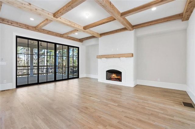 unfurnished living room featuring beamed ceiling, coffered ceiling, a fireplace, and light hardwood / wood-style flooring