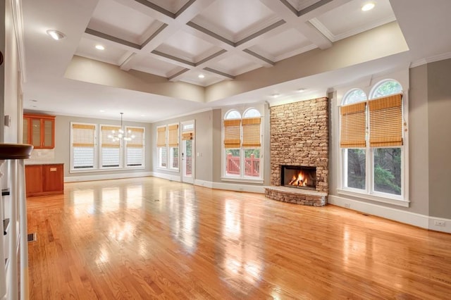 unfurnished living room featuring coffered ceiling, light wood-type flooring, a fireplace, a chandelier, and beam ceiling