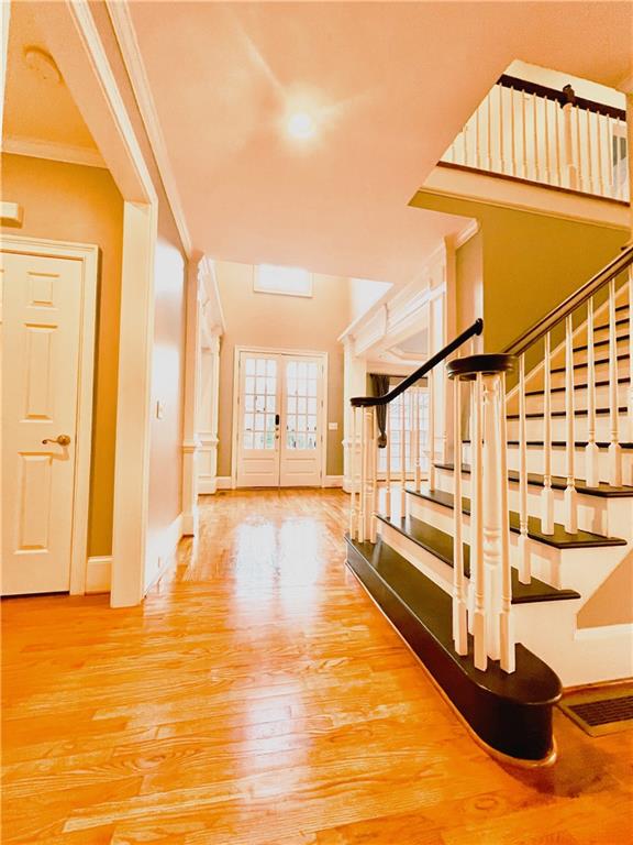 interior space featuring crown molding, wood-type flooring, and french doors