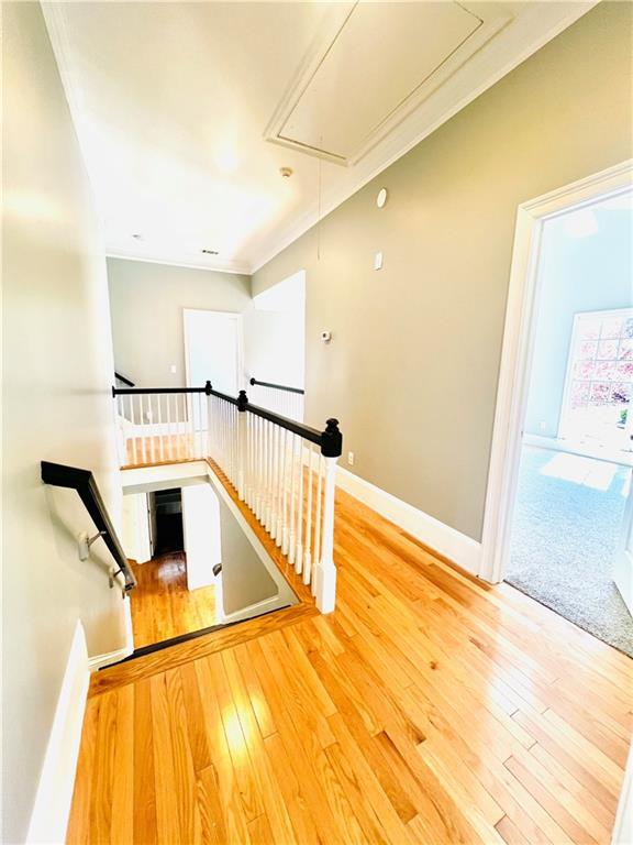 staircase with ornamental molding and hardwood / wood-style flooring