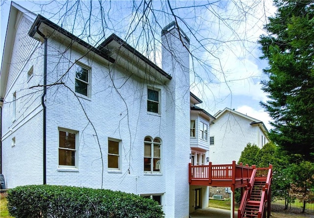 rear view of house featuring a wooden deck