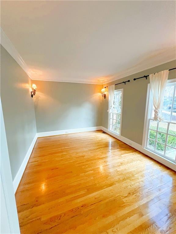 empty room featuring hardwood / wood-style flooring and ornamental molding