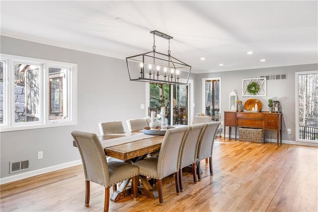 dining area featuring light wood-type flooring, visible vents, and a wealth of natural light