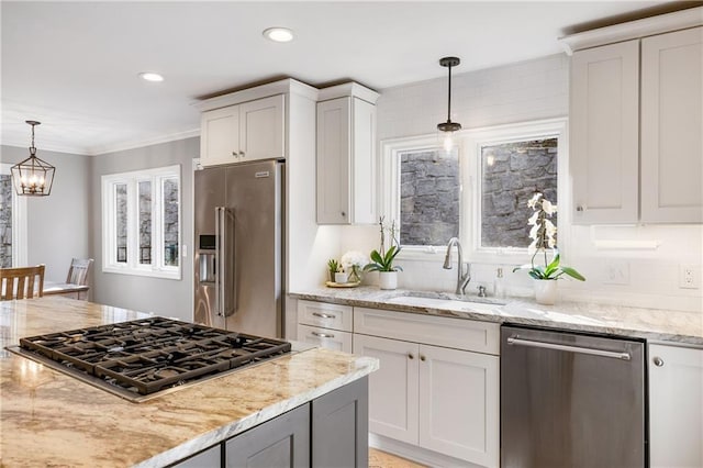 kitchen with pendant lighting, a sink, light stone counters, tasteful backsplash, and stainless steel appliances