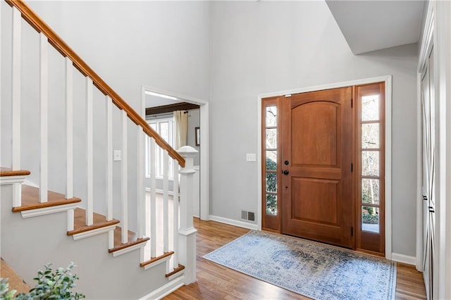 foyer featuring stairway, baseboards, visible vents, and light wood-style flooring