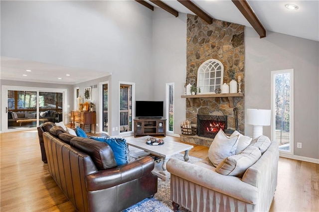 living room featuring beamed ceiling, high vaulted ceiling, light wood-style floors, a fireplace, and baseboards