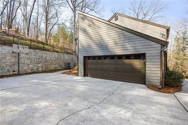 view of home's exterior featuring a garage and fence