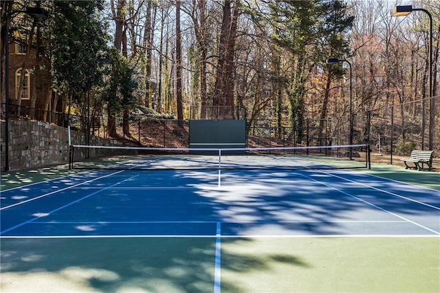 view of tennis court featuring fence