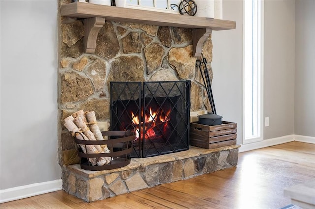 room details with baseboards, wood finished floors, and a fireplace