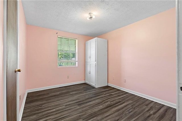 315 Pleasant Grove Rd, Mcdonough, GA 30252 - unfurnished bedroom with dark wood-type flooring, a textured ceiling, and baseboards