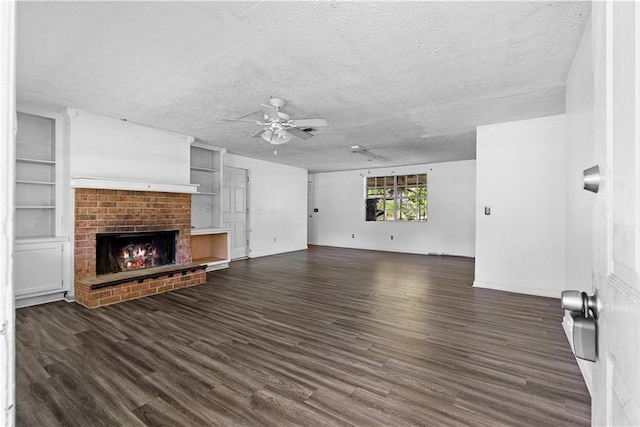 315 Pleasant Grove Rd, Mcdonough, GA 30252 - unfurnished living room featuring ceiling fan, a textured ceiling, dark wood finished floors, a fireplace, and built in features