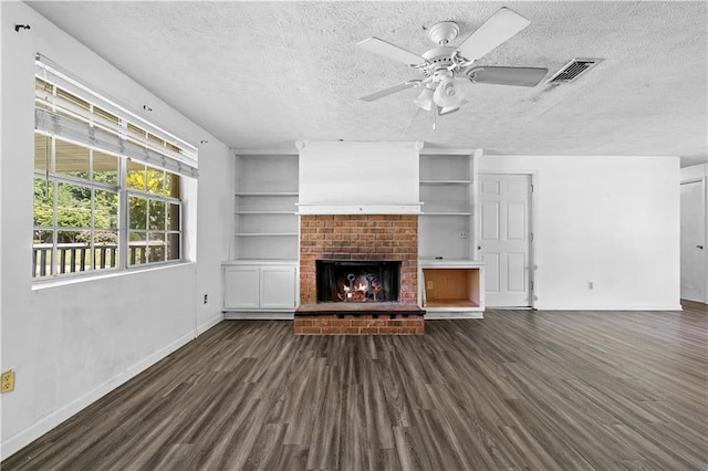 315 Pleasant Grove Rd, Mcdonough, GA 30252 - unfurnished living room featuring dark wood-style flooring, a textured ceiling, baseboards, ceiling fan, and a fireplace