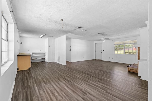 315 Pleasant Grove Rd, Mcdonough, GA 30252 - unfurnished living room with a textured ceiling, dark wood-style flooring, ceiling fan, and baseboards