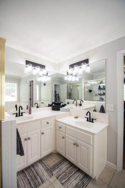 10 Stagg Trce, Social Circle, GA 30025 - full bathroom featuring tile patterned flooring, double vanity, crown molding, and a shower with shower door