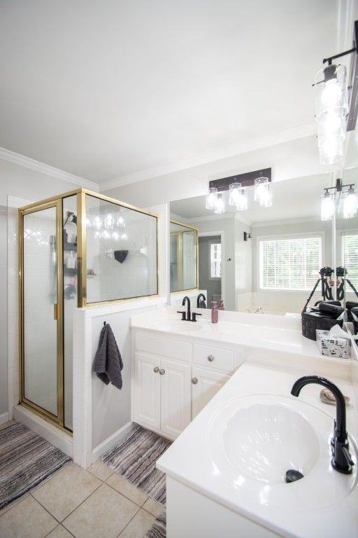 10 Stagg Trce, Social Circle, GA 30025 - bathroom with double vanity, tile patterned flooring, crown molding, and a shower stall
