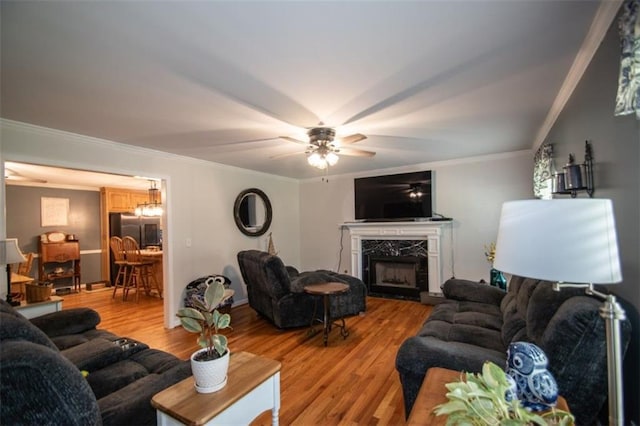 10 Stagg Trce, Social Circle, GA 30025 - living room featuring light wood-type flooring, crown molding, a premium fireplace, and a ceiling fan