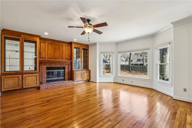 321 Covered Bridge Pl SW, Smyrna, GA 30082 - unfurnished living room with light wood-style flooring, baseboards, ceiling fan, a brick fireplace, and ornamental molding