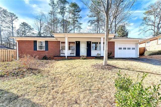 ranch-style house featuring a porch, a garage, and a front lawn