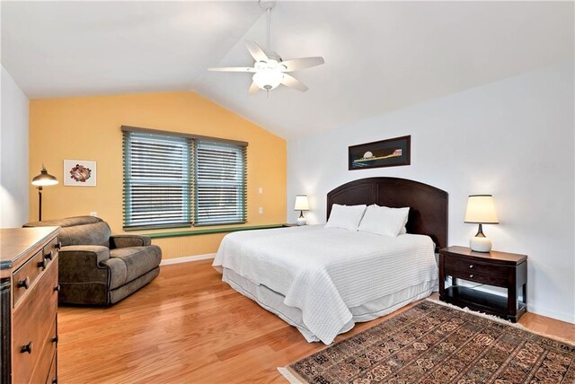 bedroom featuring lofted ceiling, light hardwood / wood-style flooring, and ceiling fan