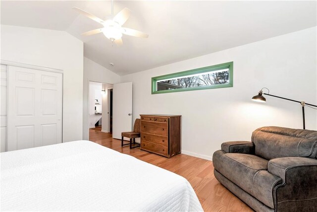 bedroom with a closet, ceiling fan, hardwood / wood-style floors, and lofted ceiling