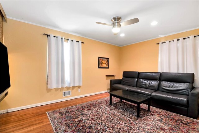 living room featuring crown molding, hardwood / wood-style flooring, and ceiling fan