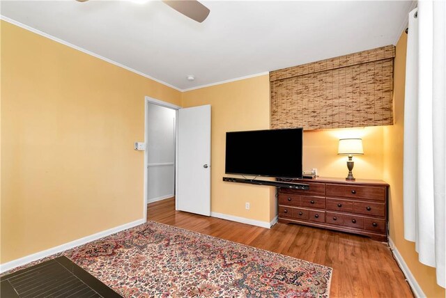 bedroom featuring light wood-type flooring, ceiling fan, and crown molding