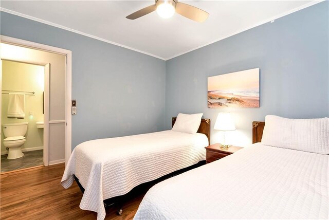 bedroom with ceiling fan, connected bathroom, crown molding, and dark wood-type flooring