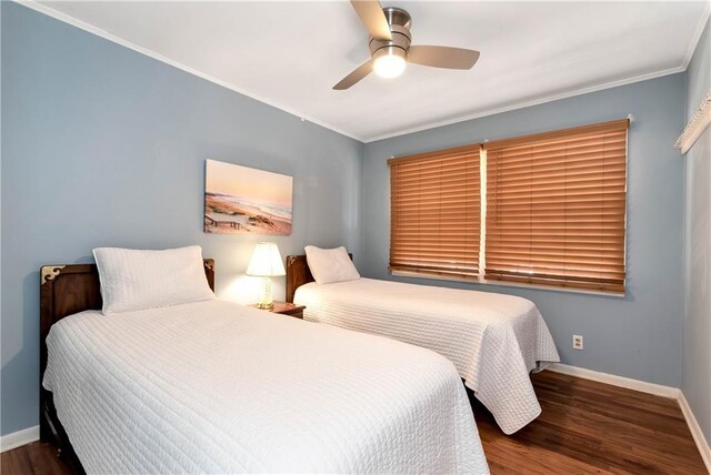 bedroom with ceiling fan, crown molding, and dark wood-type flooring