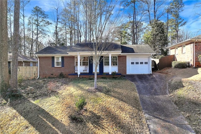 ranch-style house featuring a front yard, a porch, and a garage