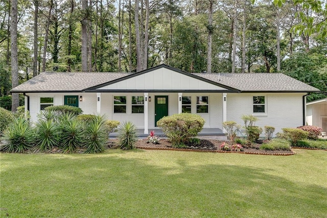 1891 Sahara Dr SE, Atlanta, GA 30316 - single story home featuring a front lawn, a porch, brick siding, view of scattered trees, and a shingled roof